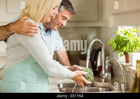 Felice Coppia matura il lavaggio di broccoli Foto Stock