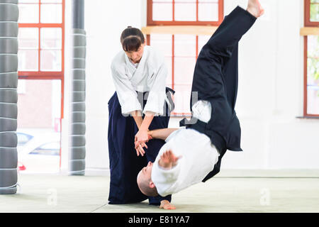 L uomo e la donna di combattere ad Aikido la formazione nella scuola di arti marziali Foto Stock