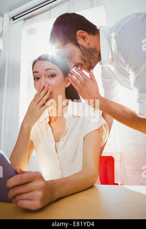 L'uomo whispering segreto in amici orecchio Foto Stock