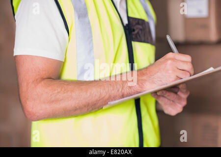 La sezione centrale del lavoratore di magazzino con clipboard Foto Stock