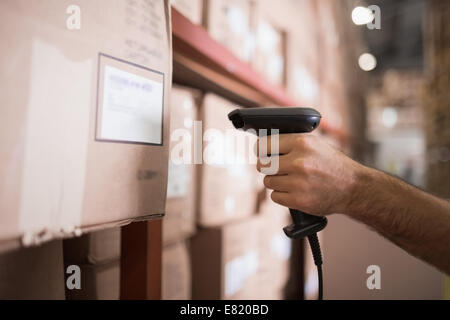 Close up di lavoratore azienda scanner in magazzino Foto Stock