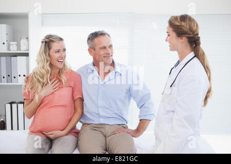 Coppia felice di parlare al medico Foto Stock