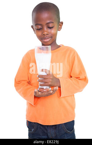 Carino ragazzo sorridente e tenendo un bicchiere di latte Foto Stock