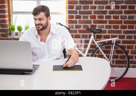 Designer casual con tavoletta grafica e il computer portatile Foto Stock