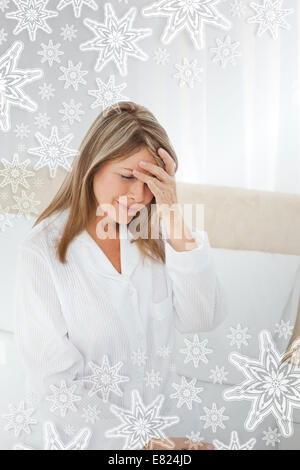 Donna con un mal di testa sul suo letto Foto Stock