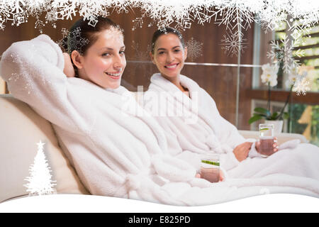 Donna sorridente in accappatoi seduta sul lettino Foto Stock