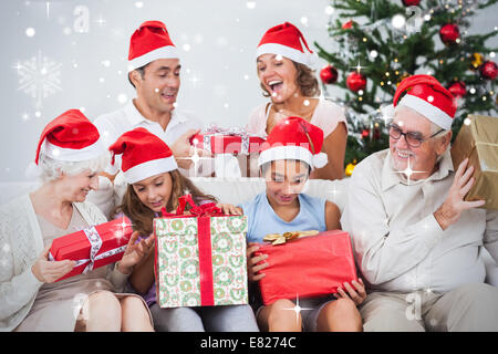 Immagine composita della famiglia eccitato scambiarsi i regali a Natale Foto Stock