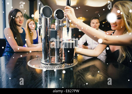 Immagine composita della donna bionda tirando una pinta di stout Foto Stock