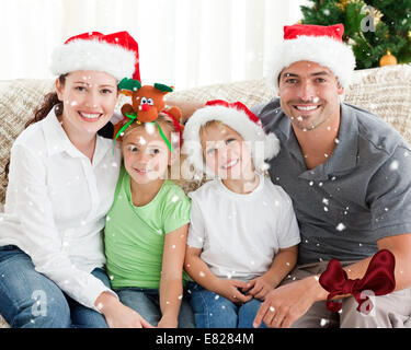 Ritratto di una famiglia felice con cappelli di Natale seduto sul divano Foto Stock