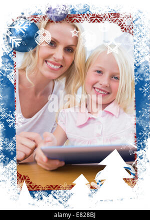 Madre utilizzando un tablet pc con sua figlia Foto Stock