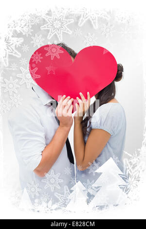 Immagine composita della giovane per la copertura del loro bacio con un cuore Foto Stock