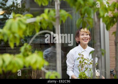 Una donna in piedi nel suo giardino. Foto Stock