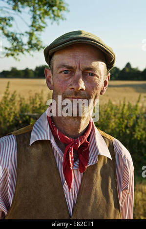 Un uomo con un rosso neckerchief e piatto hat, nel lavoro camicia e gilet. Foto Stock