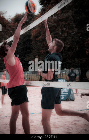 Due uomini giocando a pallavolo al netto. Foto Stock