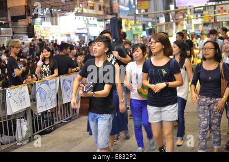 Hong Kong. 29Sep, 2014. Hong Kong proteste: gli studenti a cantare canzoni come parte di una pro-democrazia il sit-in di noto come 'occupano Central', bloccando il traffico su Yee Wo Street, una altrimenti occupato multi-lane strada transitabile a Causeway Bay Hong Kong. L'umore era calma e celebrativo, considerando che la notte prima, nella Admiralty district, i manifestanti di fronte gas lacrimogeni, spruzzo di pepe e manganelli dalla polizia in piena sommossa ingranaggio. La centrale occupano la disobbedienza civile movimento iniziò in risposta alla Cina di decisione per consentire solo a Pechino-controllati i candidati a stare nella città del 2017 elezione al top per la posizione civile di ch Foto Stock