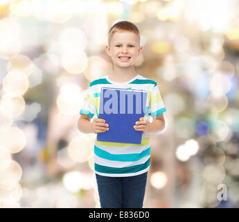 Poco sorridente studente Ragazzo con libro blu Foto Stock