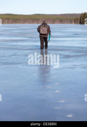 Isolato anziano che pesca sul ghiaccio a Spring , Finlandia Foto Stock