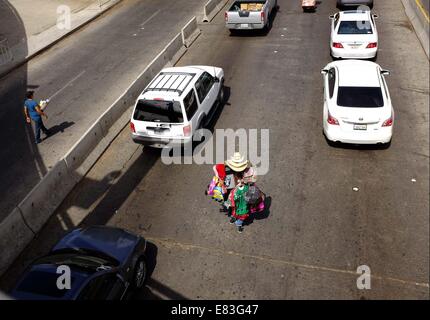 Rotolo, Baja California, Messico. Xxi Aprile, 2014. Sett. 18, 2014 -- Tijuana, Messico -- Un hawker porta la sua merce attraverso le stradine che conducono al San Ysidro valico di frontiera di vendere a persone in attesa in auto.  Obbligatorio Photo Credit: Foto di Earnie Grafton/ Copyright Earnie Grafton 2014 © Earnie Grafton/ZUMA filo/Alamy Live News Foto Stock