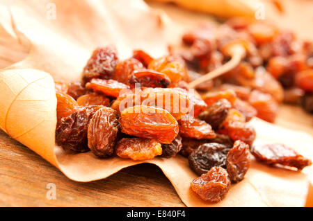 Primo piano di una pila di uva sultanina su una foglia di autunno Foto Stock