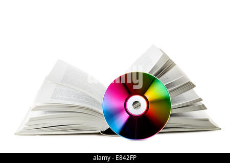 Libro aperto con vicino un compact disk, su sfondo bianco Foto Stock