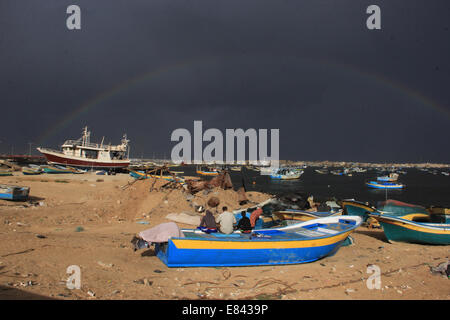 Pescatore con la sua famiglia tranquillamente seduto sulla barca guardando l'arcobaleno nel cielo, a Gaza Seaport. © Ahmed Hjazy/Pacific Press/Alamy Live News Foto Stock