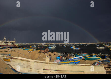 Pescatore con la sua famiglia tranquillamente seduto sulla barca guardando l'arcobaleno nel cielo, a Gaza Seaport. © Ahmed Hjazy/Pacific Press/Alamy Live News Foto Stock