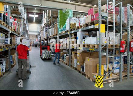 Due lavoratori in un magazzino a scaffali alti. Foto Stock