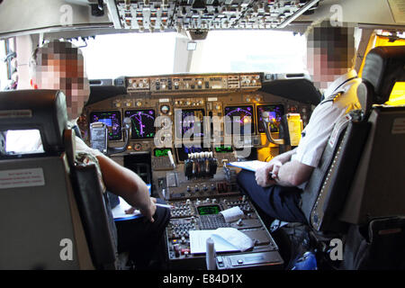 Un pilota e il primo ufficiale (facce disturbato) presso i comandi in cabina di pilotaggio di un Boeing 747 Jumbo Jet sul terreno a Heathrow Foto Stock