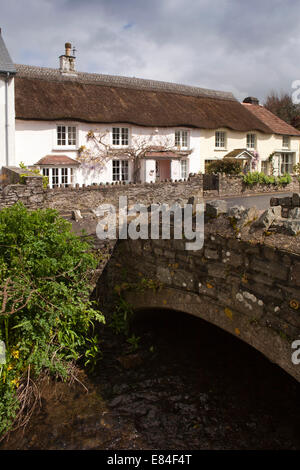 Regno Unito, Inghilterra, Devon, Croyde, cottage con il tetto di paglia accanto a flusso passante attraverso il villaggio Foto Stock