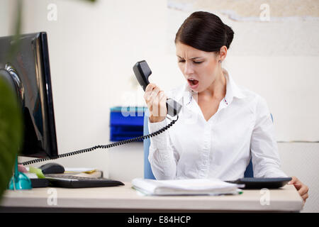 Donna arrabbiato grida al telefono Foto Stock