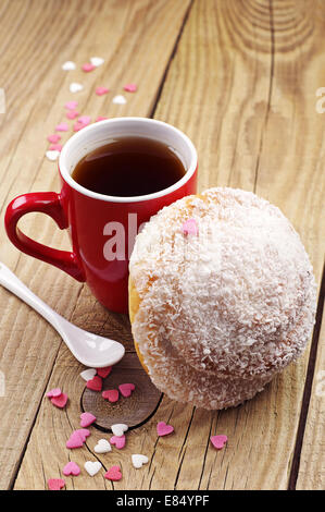 Deliziosa la pagnotta con scaglie di noce di cocco e la tazza di tè caldo Foto Stock