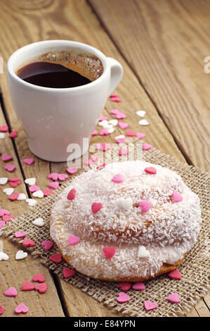 La pagnotta con scaglie di noce di cocco e la tazza di caffè caldo Foto Stock