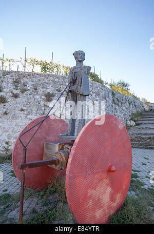 Statua in piedi su due grandi ruote rosse in Montalcino Italia Foto Stock