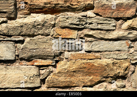 Vecchio muro di pietre di colore rossastro Foto Stock