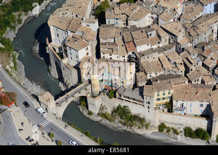 VISTA AEREA. Villaggio medievale ben protetto accessibile solo da un ponte sul fiume Var. Entrevaux, Alpi dell'alta Provenza, Francia. Foto Stock