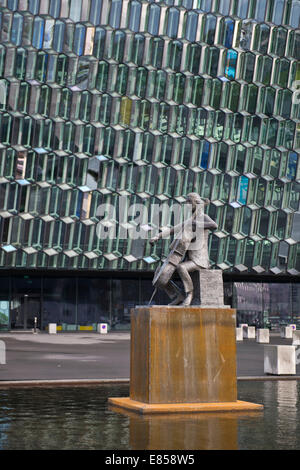 Un monumento di fronte Harpa concert hall e il centro conferenze, il nuovo edificio di Reykjavík, Islanda Foto Stock