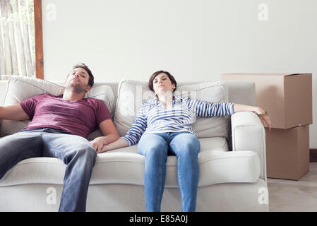 Giovane rilassante sul divano mentre casa in movimento Foto Stock