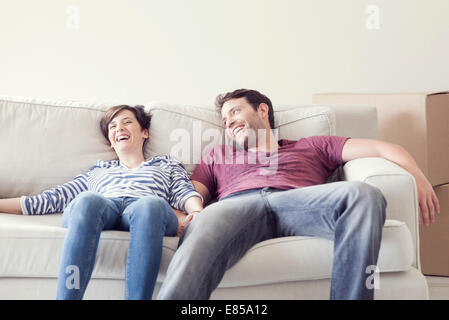 Giovane rilassante sul divano mentre casa in movimento Foto Stock