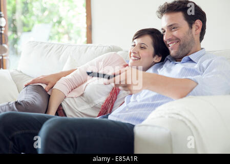 Paio di guardare la TV insieme sul divano Foto Stock