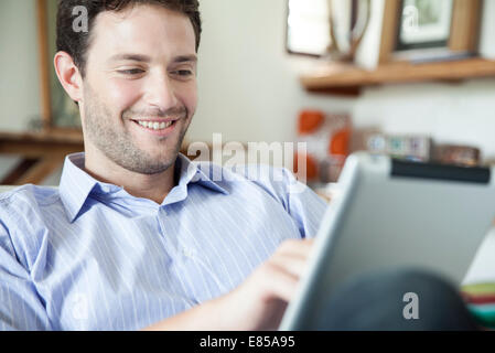 Uomo con tavoletta digitale in casa Foto Stock