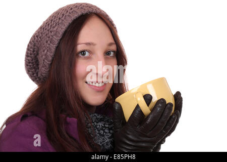 Ritratto di una giovane donna di bere tazza di tè in inverno, isolato su sfondo bianco Foto Stock