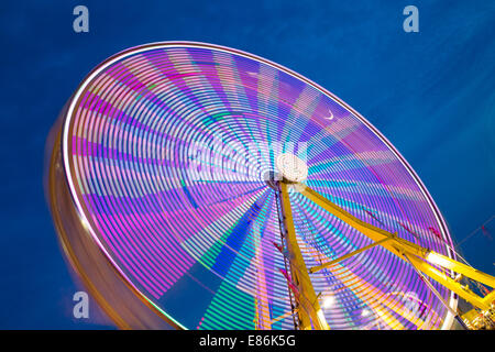 Un colorato ruota panoramica Ferris prese con una lunga esposizione che mostra i diversi colori Foto Stock