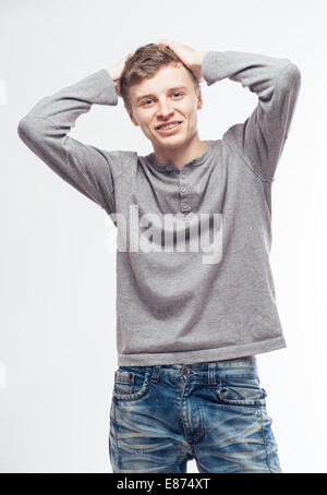 L'uomo tenendo le mani dietro la testa e sorridente Foto Stock