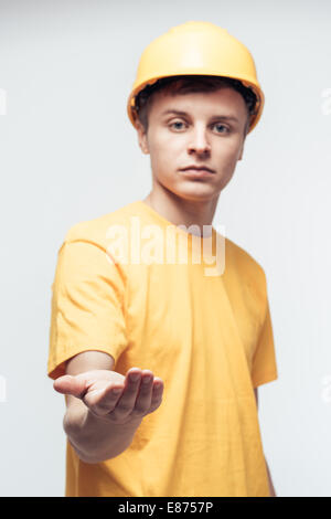 Lavoratore nel casco giallo con braccio teso Foto Stock