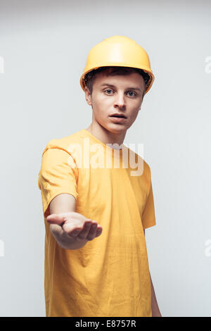 Lavoratore nel casco giallo con braccio teso Foto Stock