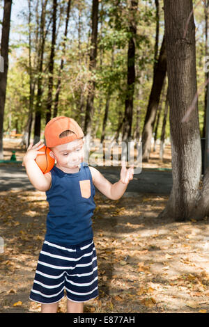 Grazioso fanciullo ragazzo nel parco sulla natura in estate. Utilizzarlo per bambino, genitorialità o il concetto di amore Foto Stock