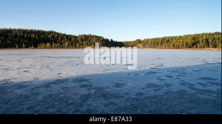 La fusione, sottile e debole di ghiaccio su un piccolo lago di foresta in primavera , Finlandia Foto Stock