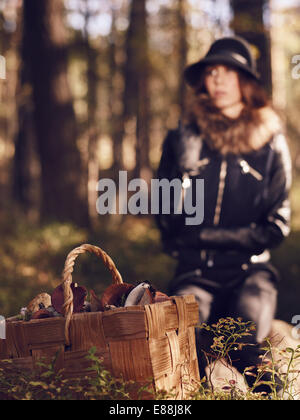 Moda donna bella e cesto di funghi, focus sul carrello - caldo immagine oscurata Foto Stock