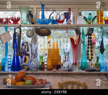 La raccolta di vetro colorato di bottiglie e vasetti di vetro sui ripiani Foto Stock