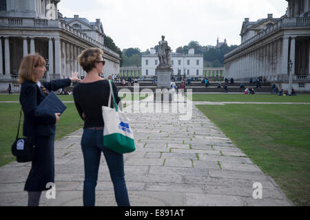 Ottobre 2014: due donne guardando sopra la statua di George II nella motivazione dell'Università di Greenwich Foto Stock